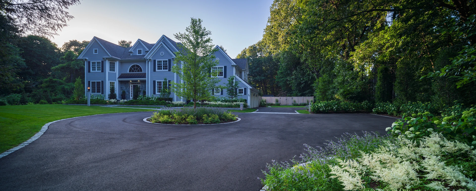 Fine Gardening & Landscape Design Luxury fine gardening with white and purple flowers lining the driveway of a Wayland, MA residential property.