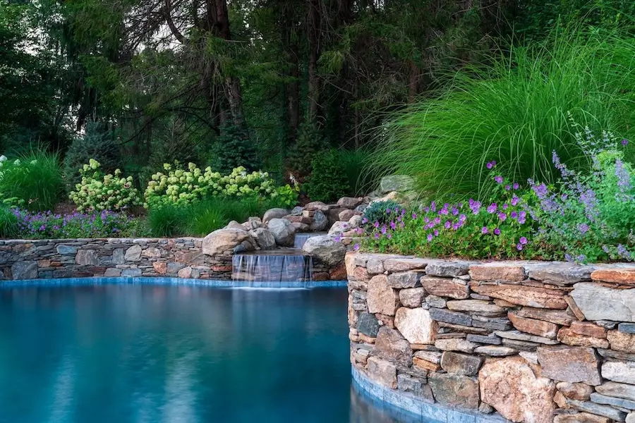landscape design with ornamental shrubs and masonry in massachusetts