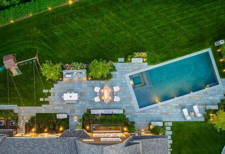 landscape design aerial shot in Massachusetts featuring a stone patio and pool landscaping